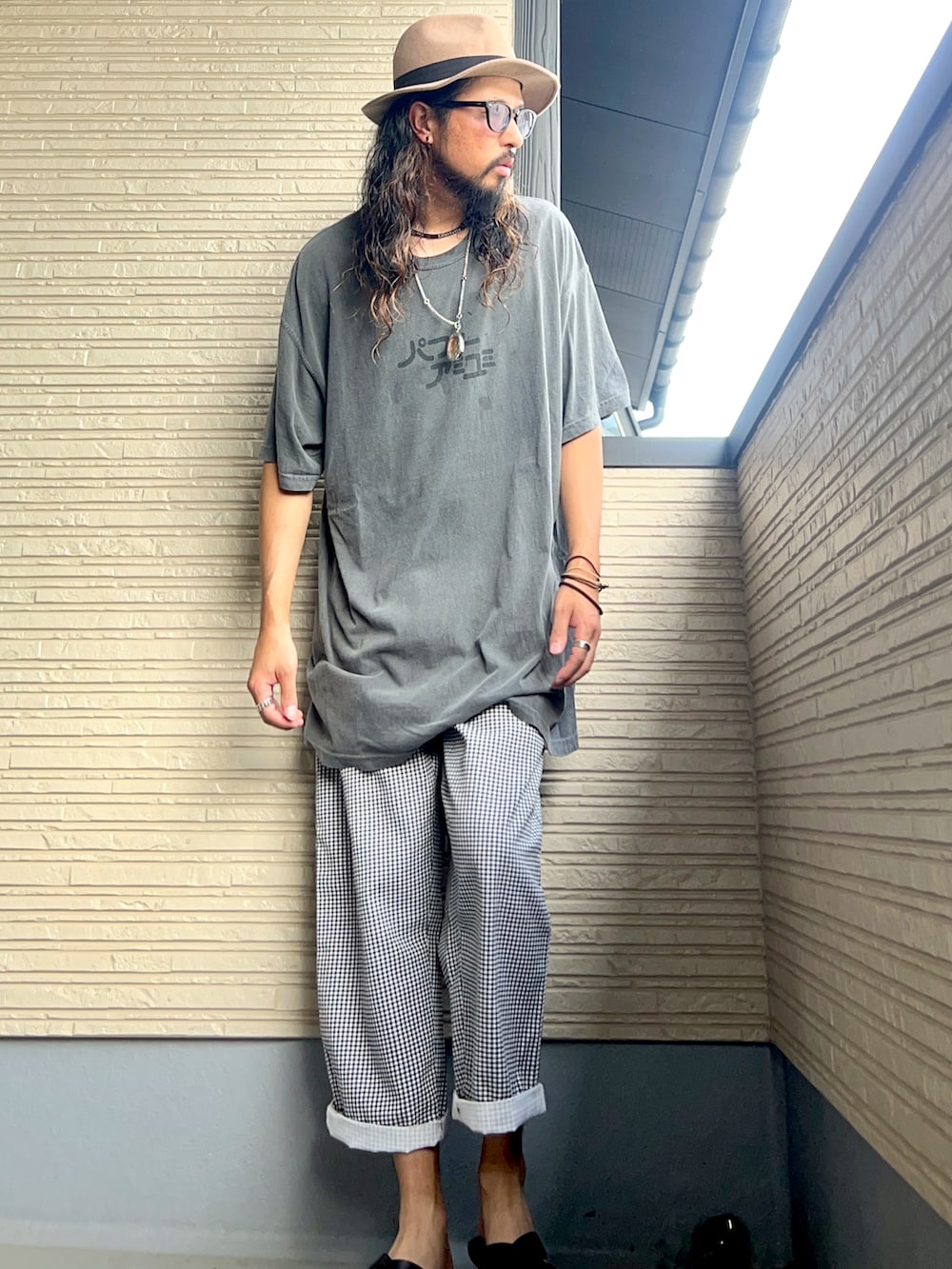 グレー系のTシャツ/カットソー、ホワイト系のその他パンツ、ブラック系のサンダルを着用したメンズの秋コーディネートの3枚目の写真