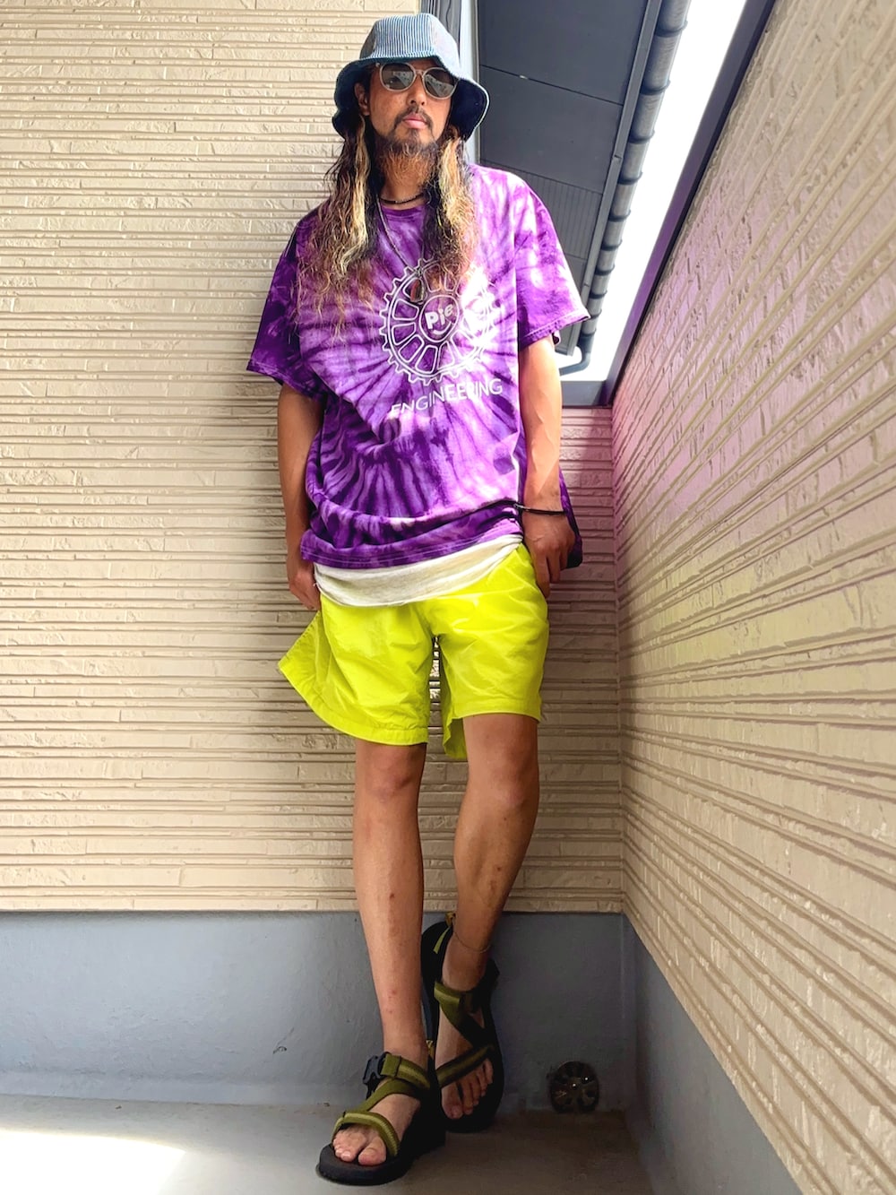 パープル系のTシャツ/カットソー、イエロー系のその他パンツ、グリーン系のサンダルを着用したメンズの夏コーディネートの3枚目の写真