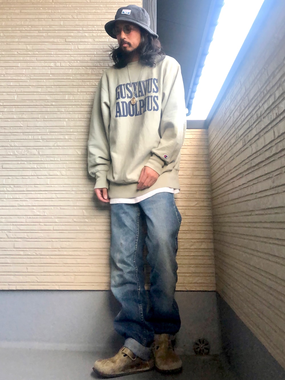 グレー系のスウェット、ブルー系のパンツ、グリーン系のシューズを着用したメンズの秋コーディネートの2枚目の写真