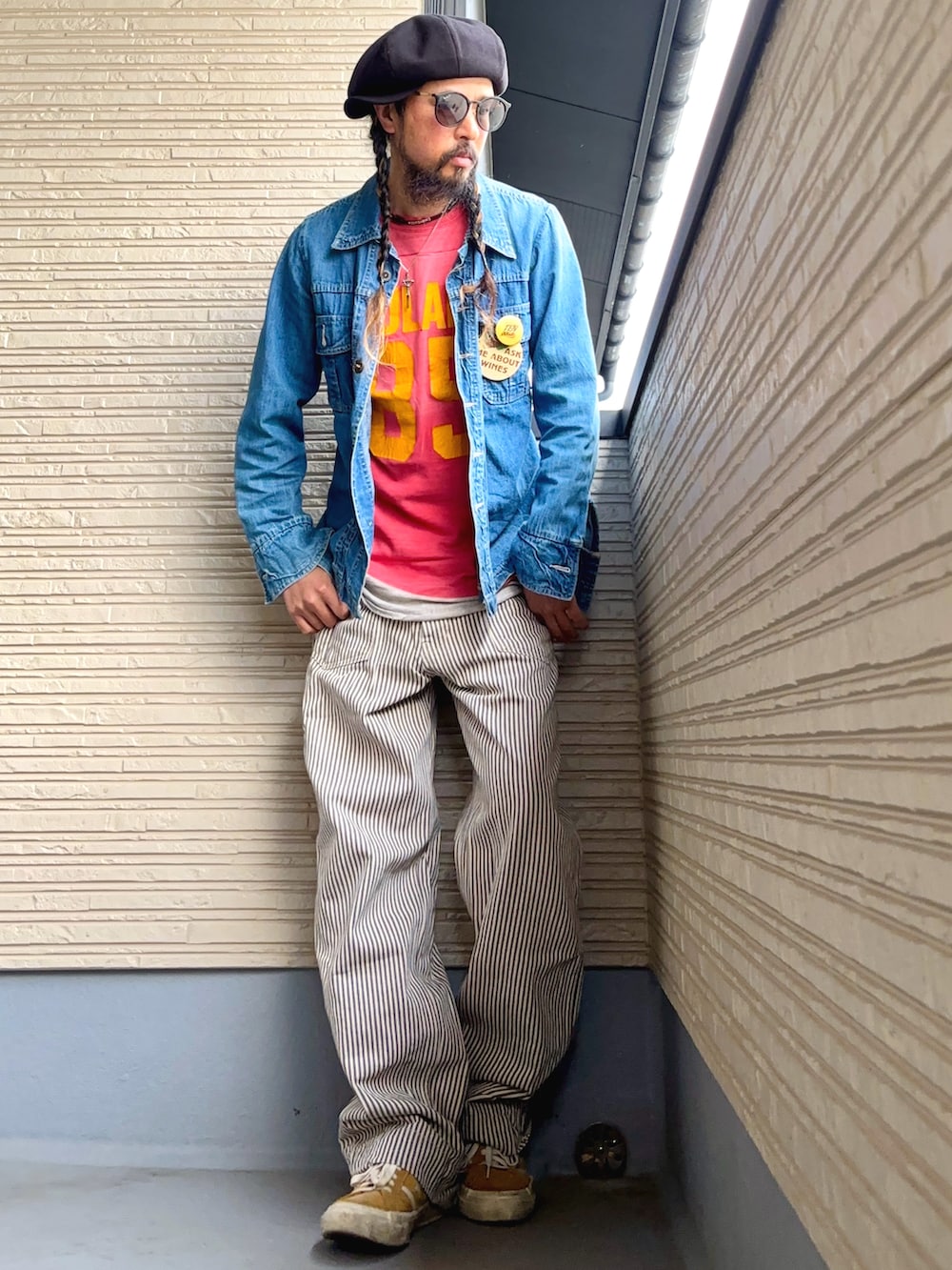 レッド系のTシャツ/カットソー、ブルー系のデニムジャケット、ベージュ系のパンツを着用したメンズの春コーディネートの2枚目の写真