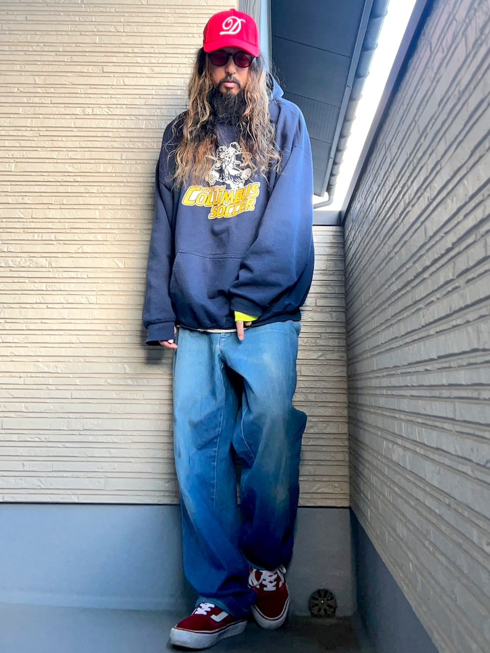 ブルー系のパーカー、ブルー系のデニムパンツ、レッド系のスニーカーを着用したメンズの冬コーディネートの2枚目の写真