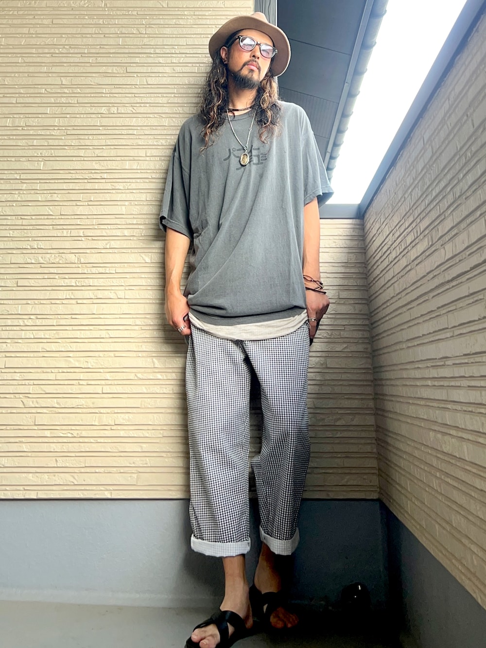 グレー系のTシャツ/カットソー、ホワイト系のその他パンツ、ブラック系のサンダルを着用したメンズの秋コーディネートの2枚目の写真