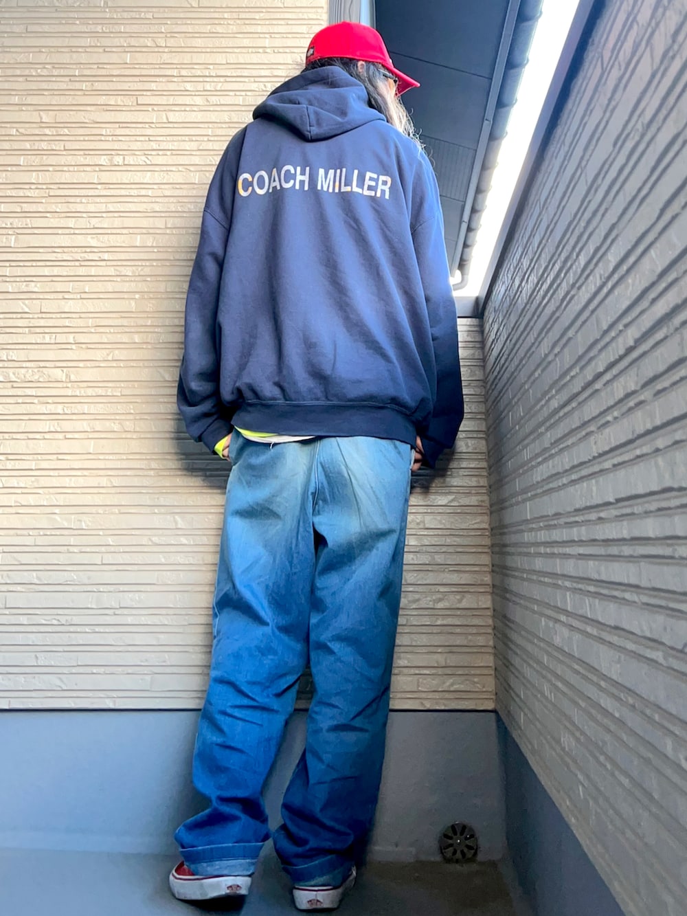 ブルー系のパーカー、ブルー系のデニムパンツ、レッド系のスニーカーを着用したメンズの冬コーディネートの4枚目の写真