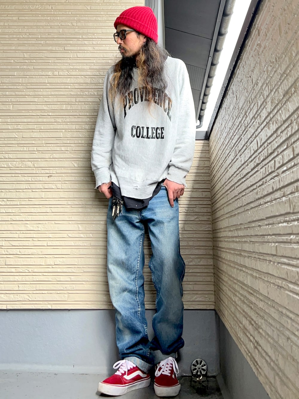 グレー系のスウェット、ブルー系のパンツ、レッド系のスニーカーを着用したメンズの春コーディネートの2枚目の写真