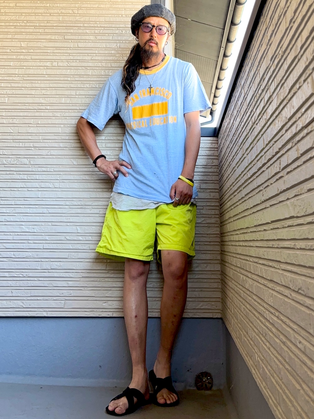ブルー系のTシャツ/カットソー、イエロー系のその他パンツ、ブラック系のサンダルを着用したメンズの夏コーディネートの3枚目の写真