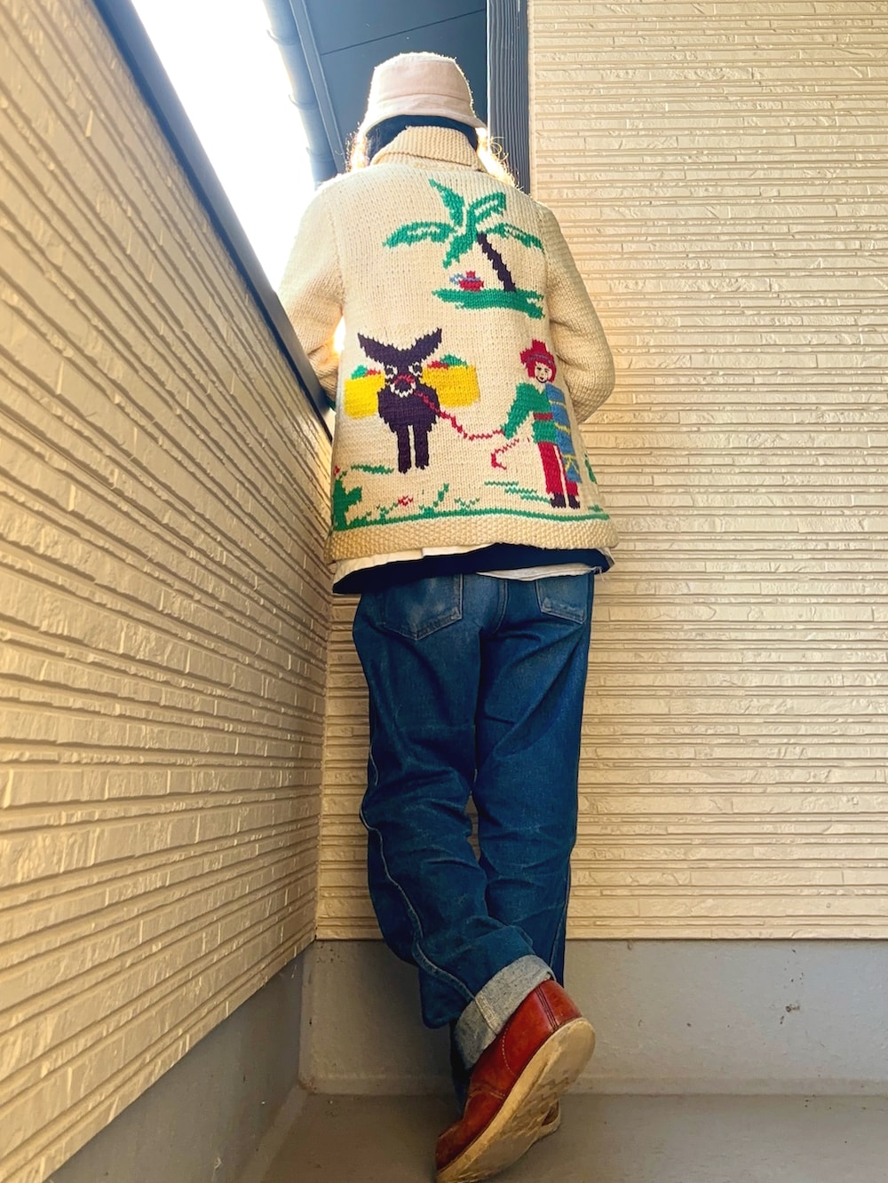 ベージュ系のカーディガン/ボレロ、ホワイト系のTシャツ/カットソー、ブルー系のデニムパンツを着用したメンズの冬コーディネートの3枚目の写真