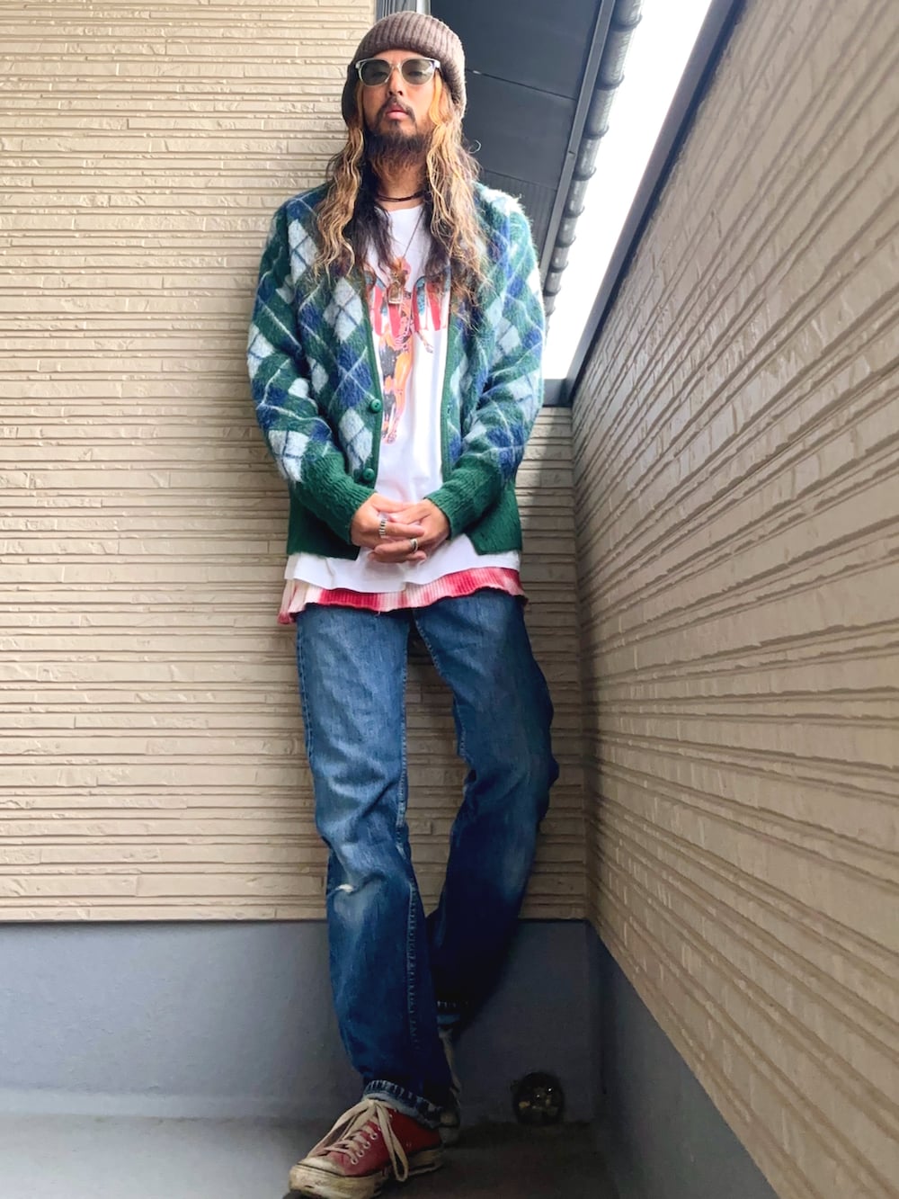 グリーン系のカーディガン/ボレロ、ホワイト系のTシャツ/カットソー、ブルー系のデニムパンツを着用したメンズの秋コーディネートの4枚目の写真