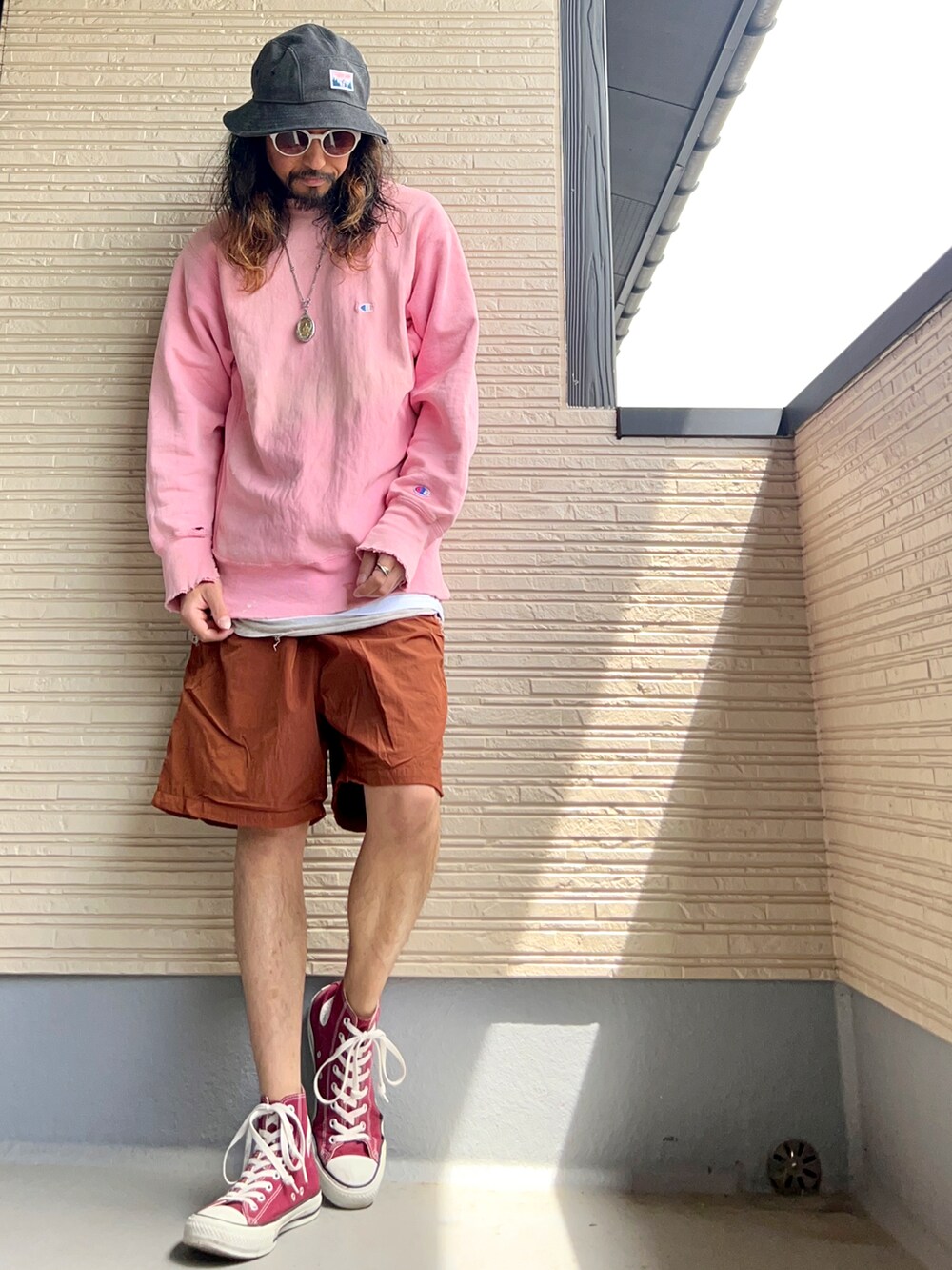 ピンク系のスウェット、ブラウン系のその他パンツ、レッド系のスニーカーを着用したメンズの春コーディネートの3枚目の写真