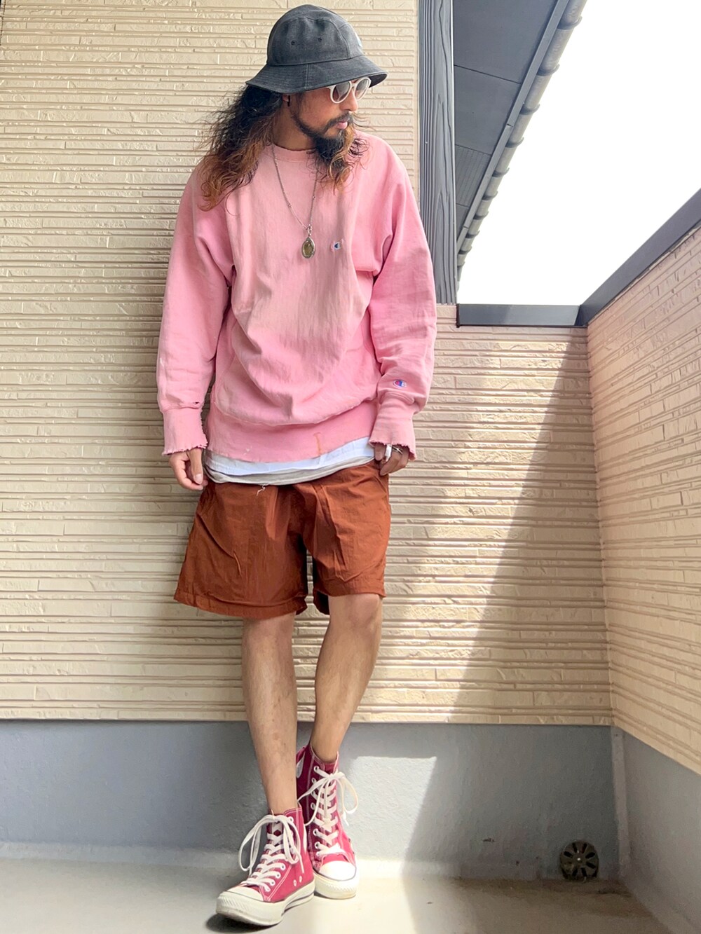 ピンク系のスウェット、ブラウン系のその他パンツ、レッド系のスニーカーを着用したメンズの春コーディネートの2枚目の写真