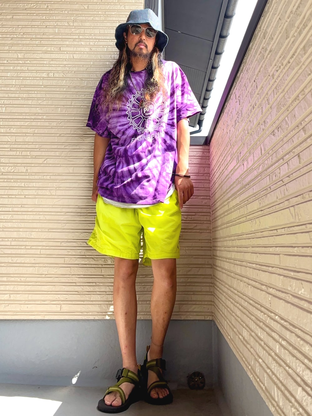 パープル系のTシャツ/カットソー、イエロー系のその他パンツ、グリーン系のサンダルを着用したメンズの夏コーディネートの5枚目の写真