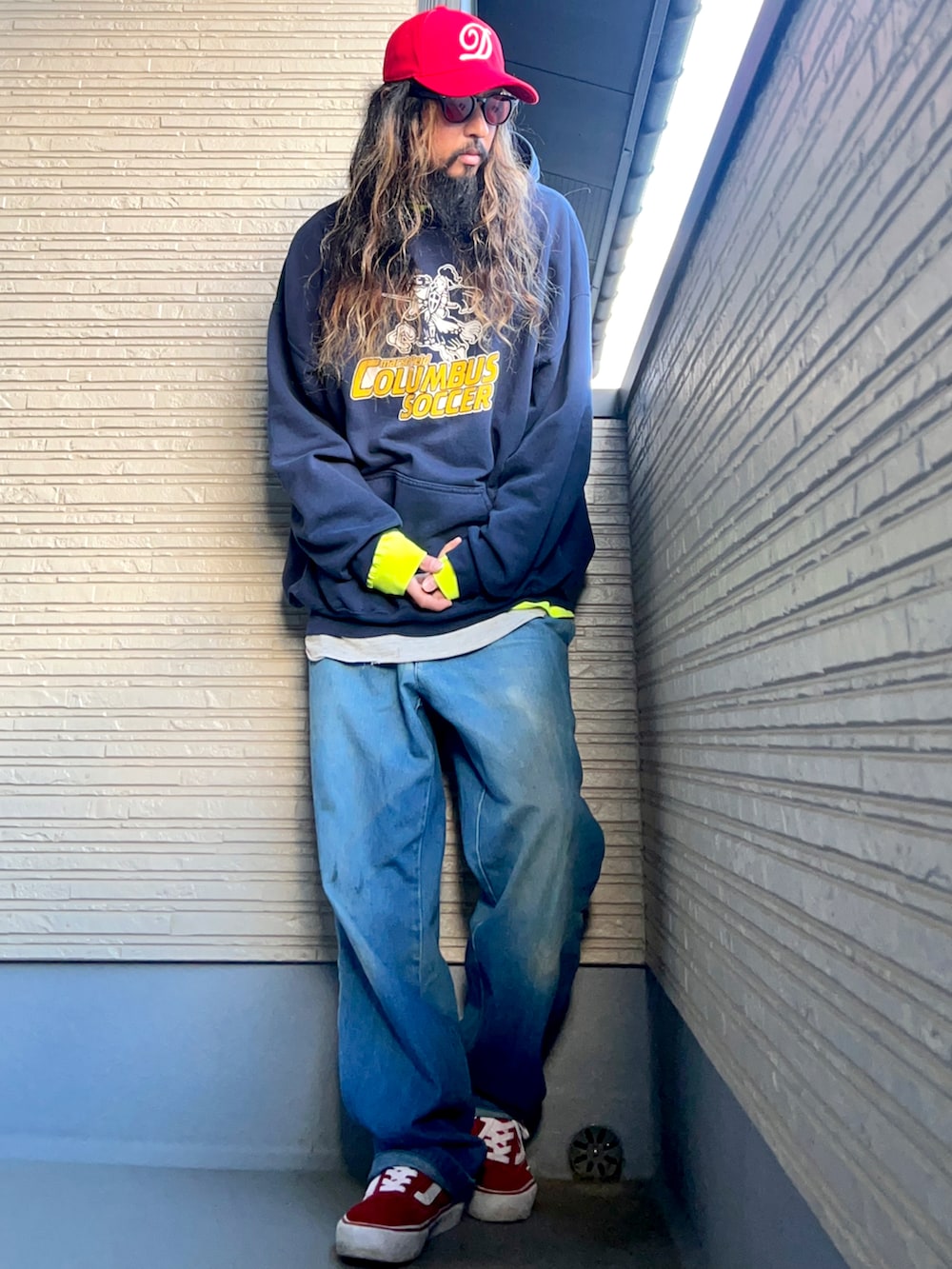 ブルー系のパーカー、ブルー系のデニムパンツ、レッド系のスニーカーを着用したメンズの冬コーディネートの3枚目の写真