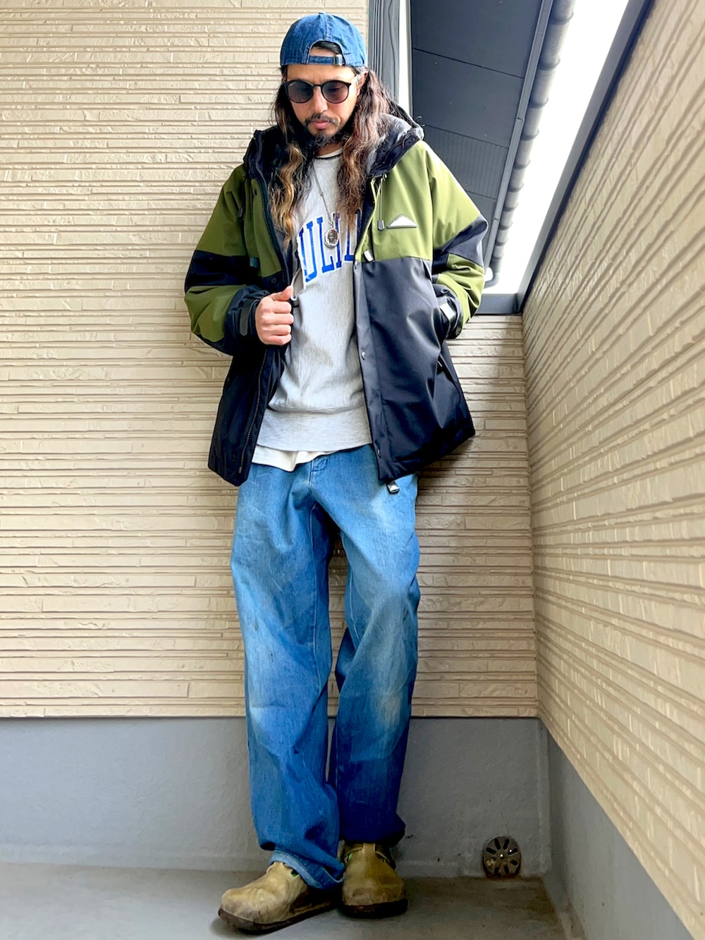 グリーン系のジャケット/アウター、グレー系のスウェット、ブルー系のデニムパンツを着用したメンズの冬コーディネートの2枚目の写真