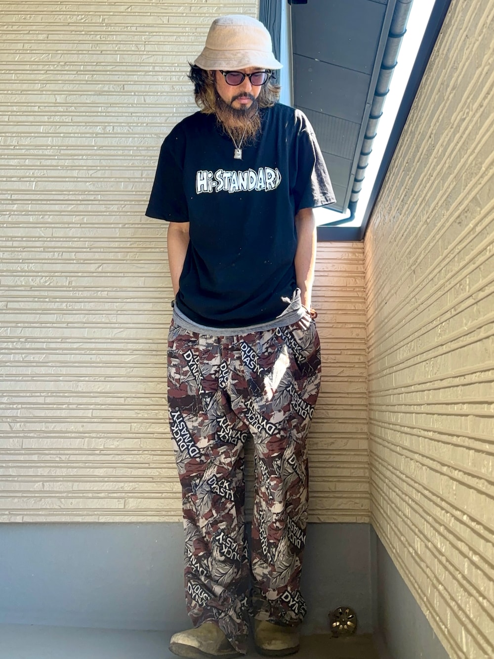 ブラック系のTシャツ/カットソー、ブラウン系のその他パンツ、グリーン系のシューズを着用したメンズの春コーディネートの2枚目の写真