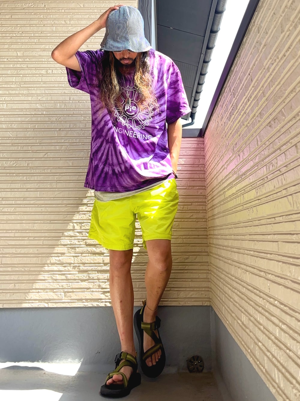 パープル系のTシャツ/カットソー、イエロー系のその他パンツ、グリーン系のサンダルを着用したメンズの夏コーディネートの2枚目の写真