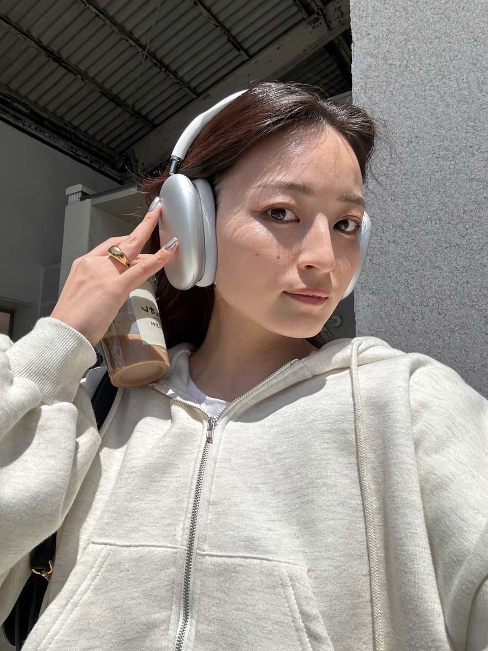 ブラック系のバッグ、ホワイト系のセットアップ、ブラック系のスニーカーを着用したレディースの春コーディネートの2枚目の写真