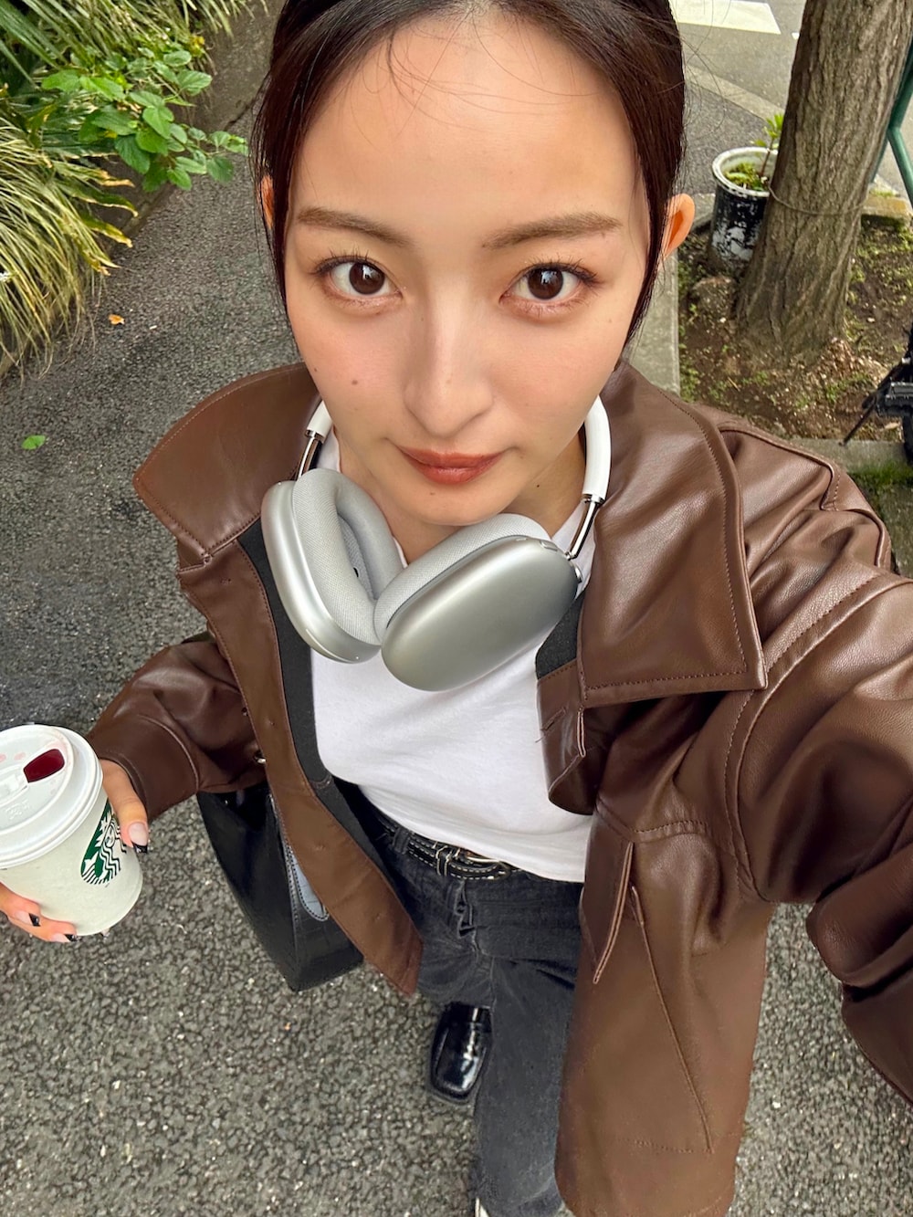 ブラック系のバッグ、ブラック系のデニムパンツ、ブラック系のローファーを着用したレディースの春コーディネートの2枚目の写真