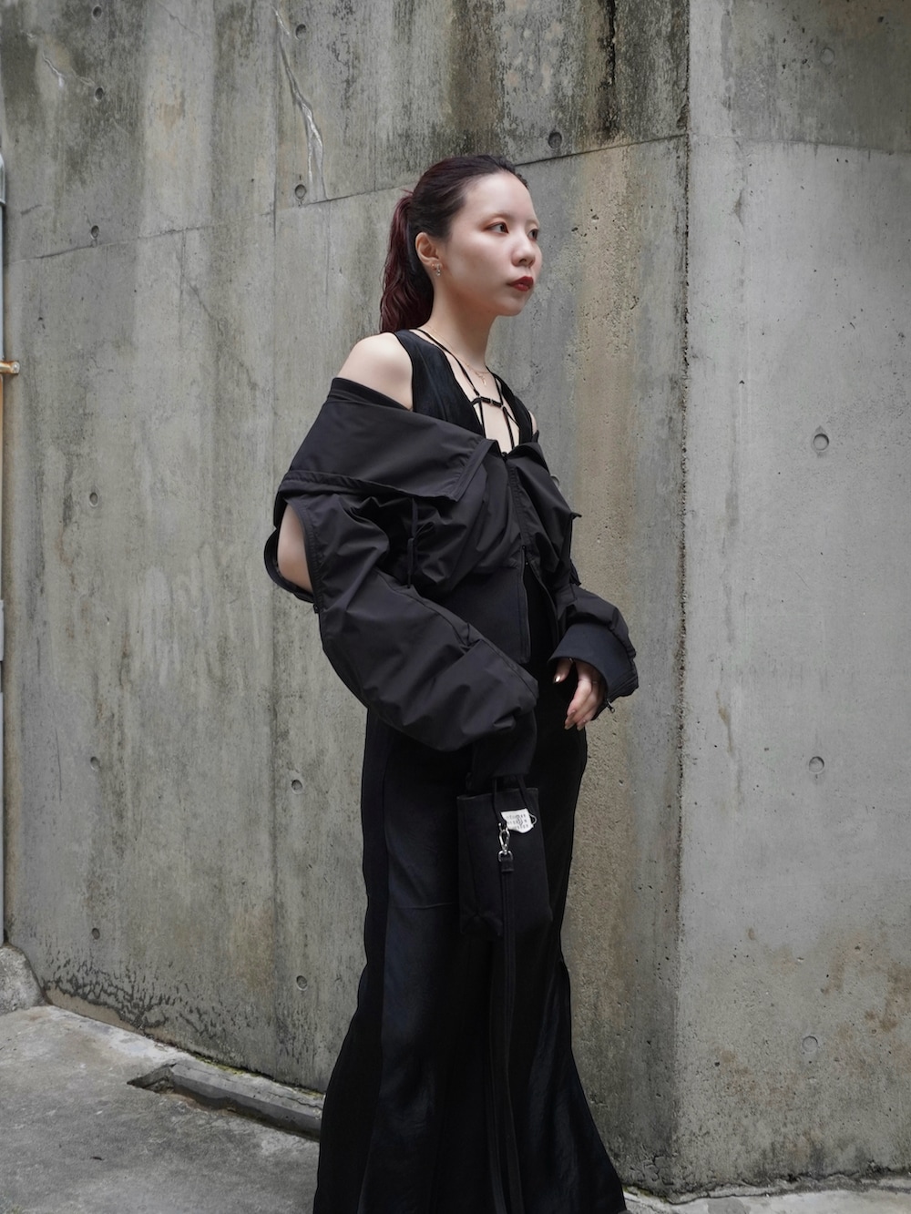 ブラック系のワンピース、ブラック系のパーカー、ブラック系のハンドバッグを着用したレディースの春コーディネートの2枚目の写真