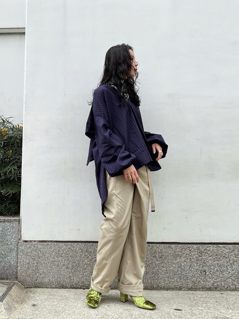 ベージュ系のパンツ、レッド系のシャツ/ブラウス、グリーン系のTシャツ/カットソーを着用したレディースの冬コーディネートの3枚目の写真