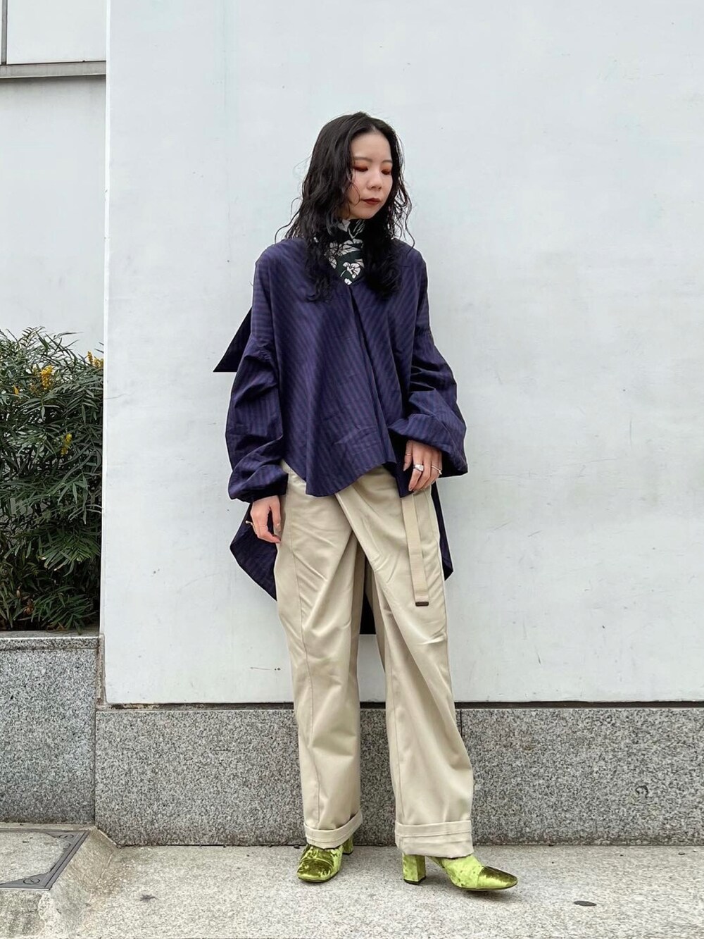 ベージュ系のパンツ、レッド系のシャツ/ブラウス、グリーン系のTシャツ/カットソーを着用したレディースの冬コーディネートの2枚目の写真