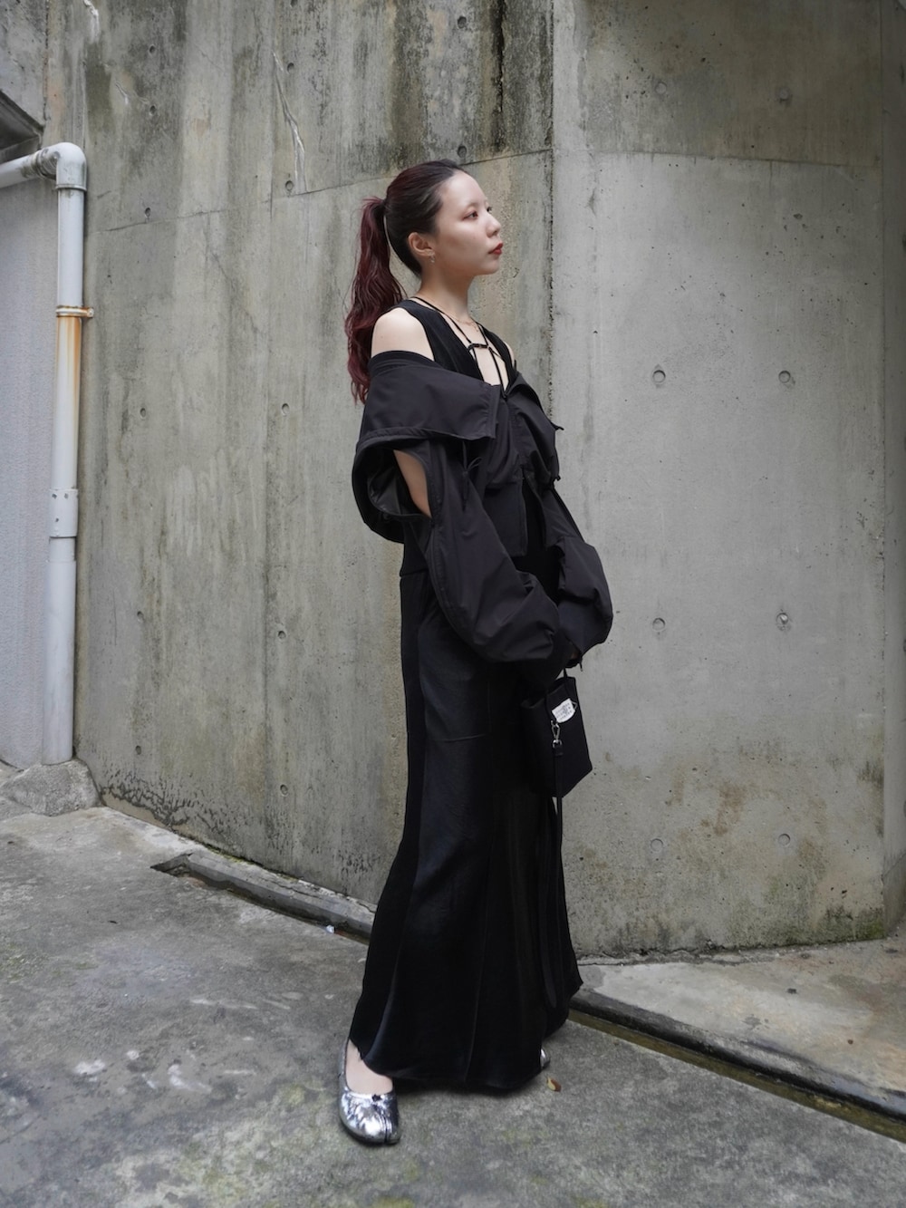 ブラック系のワンピース、ブラック系のパーカー、ブラック系のハンドバッグを着用したレディースの春コーディネートの3枚目の写真