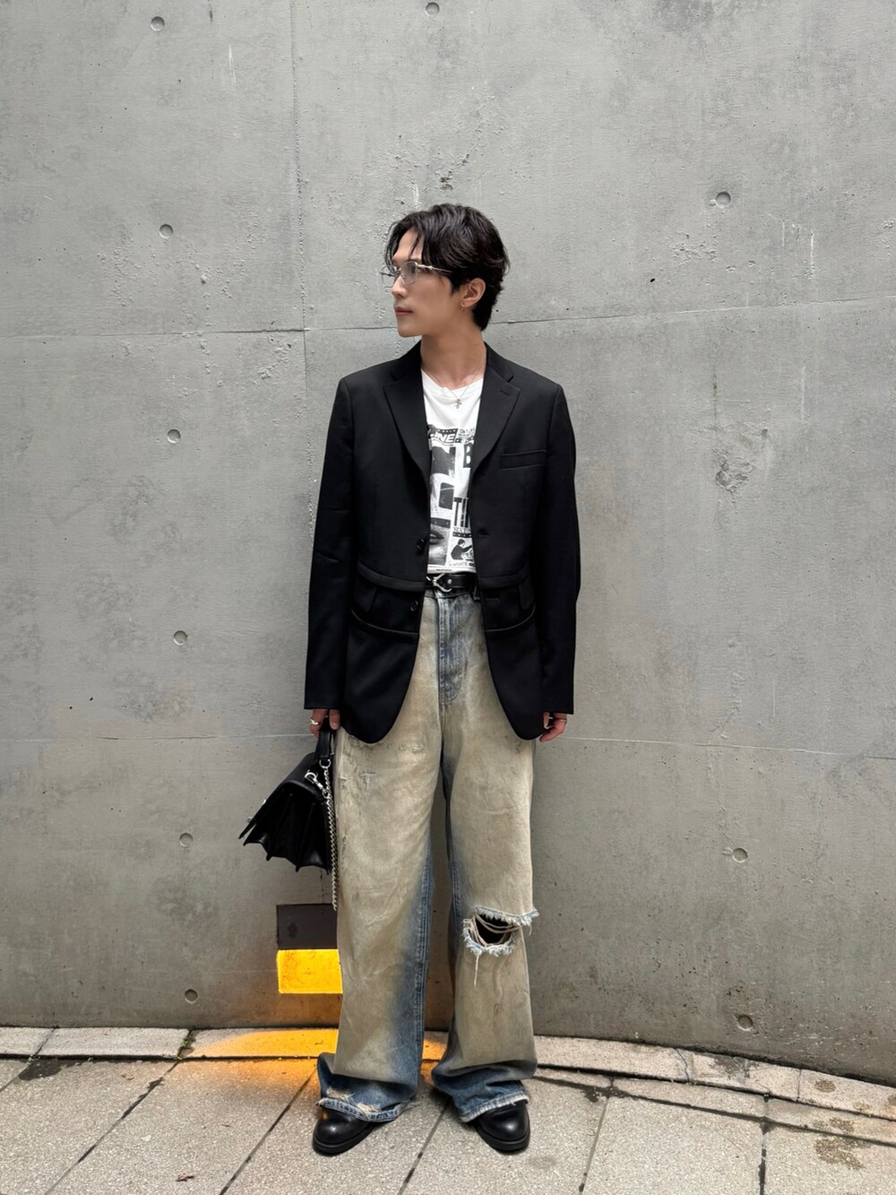 ブラック系のテーラードジャケット、ホワイト系のTシャツ/カットソー、ブラック系のブーツを着用したメンズの夏コーディネートの2枚目の写真