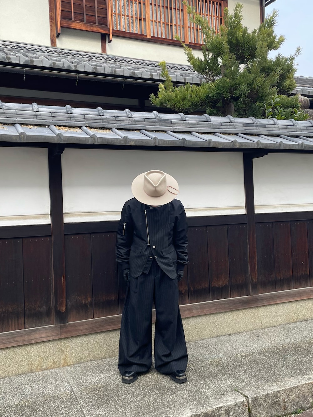 ブラック系のジャケット/アウター、ブラック系のスラックスを着用したメンズの春コーディネートの2枚目の写真