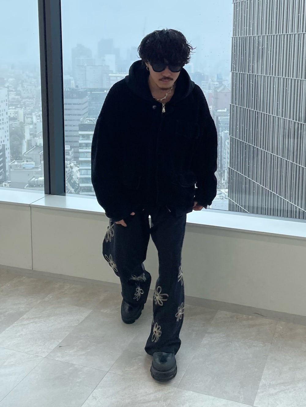 ブラック系のスラックス、ブラック系のブルゾンを着用したメンズの春コーディネートの3枚目の写真