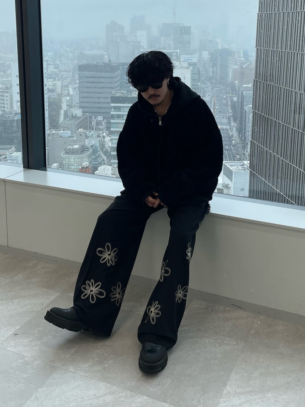 ブラック系のスラックス、ブラック系のブルゾンを着用したメンズの春コーディネートの2枚目の写真