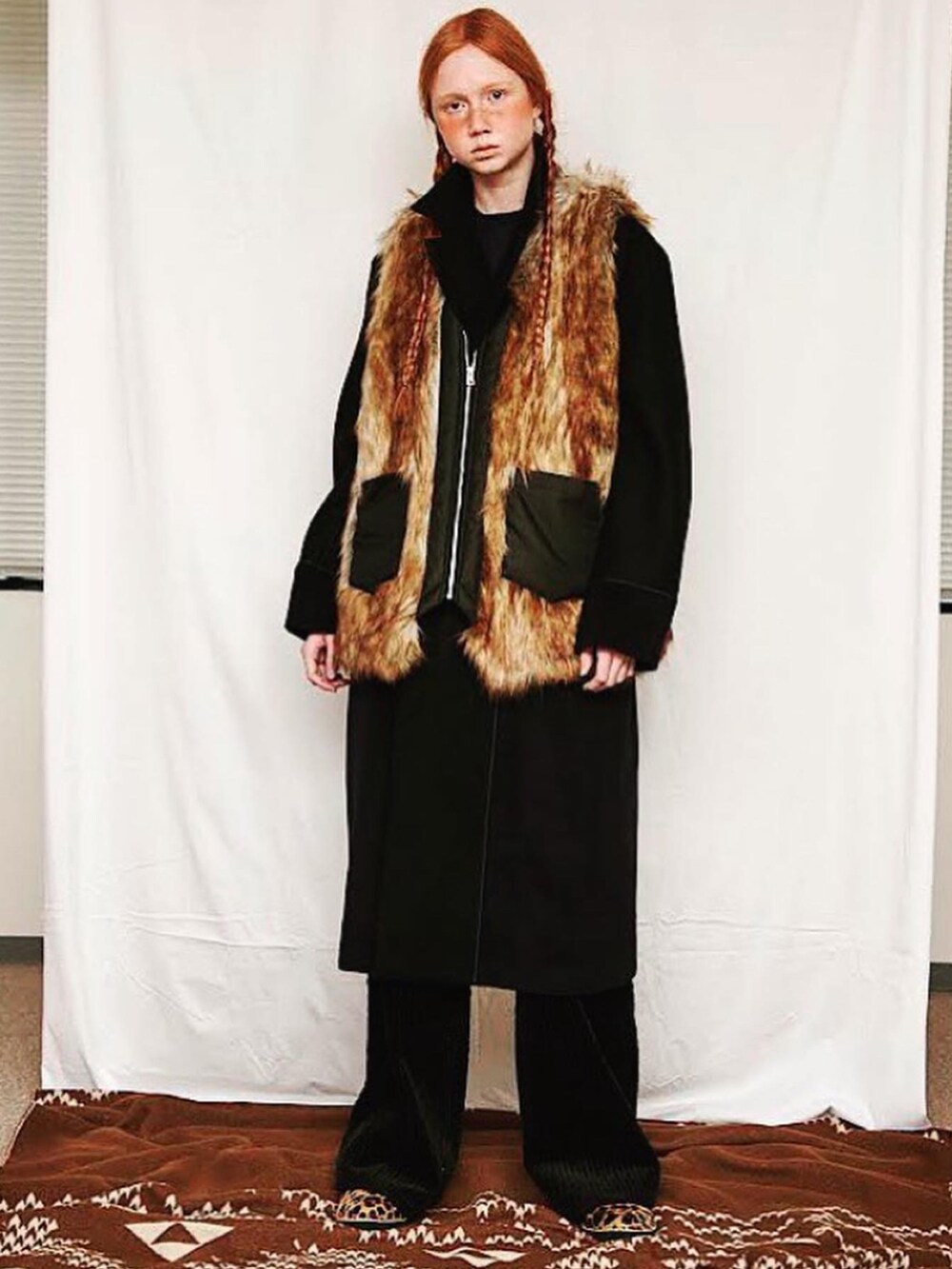 ブラウン系のベスト、ブラック系のステンカラーコートを着用したメンズの春コーディネートの5枚目の写真