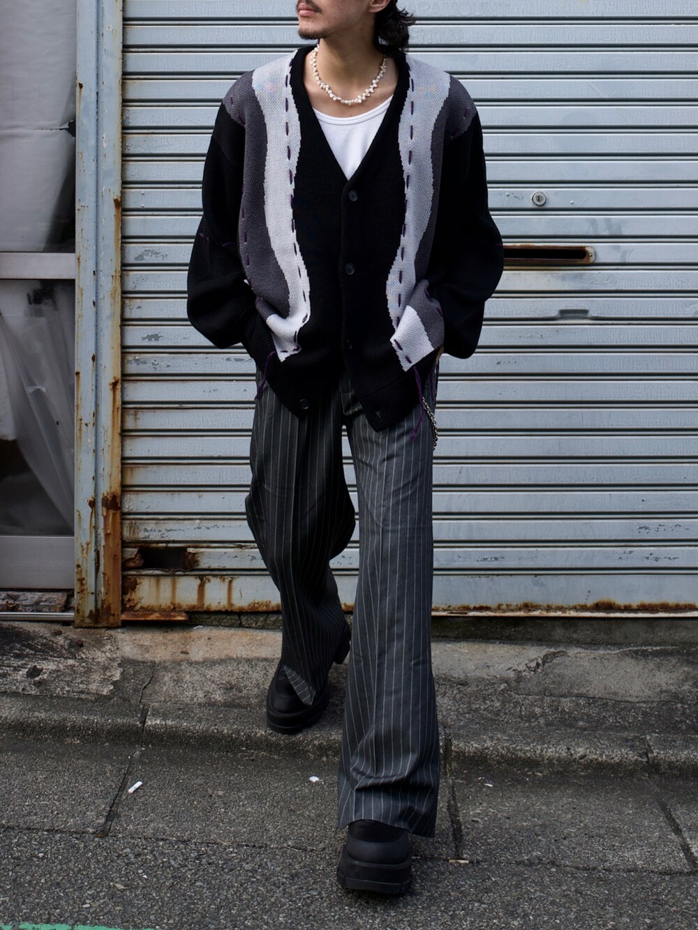ブラック系のカーディガン/ボレロ、グレー系のパンツを着用したメンズの秋コーディネートの4枚目の写真