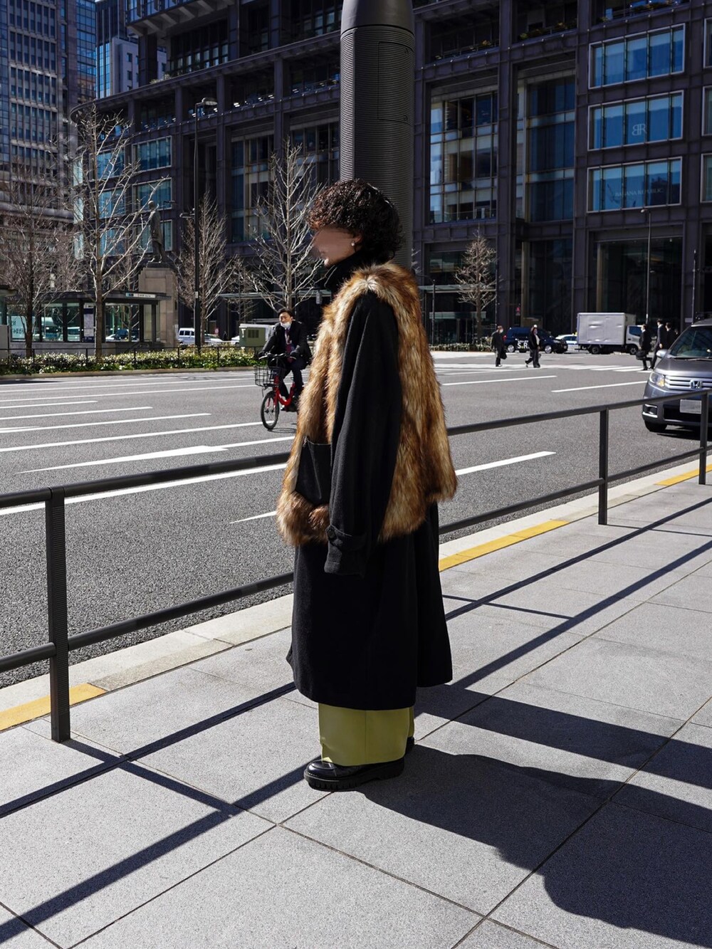 ブラウン系のベスト、ブラック系のステンカラーコートを着用したメンズの春コーディネートの3枚目の写真