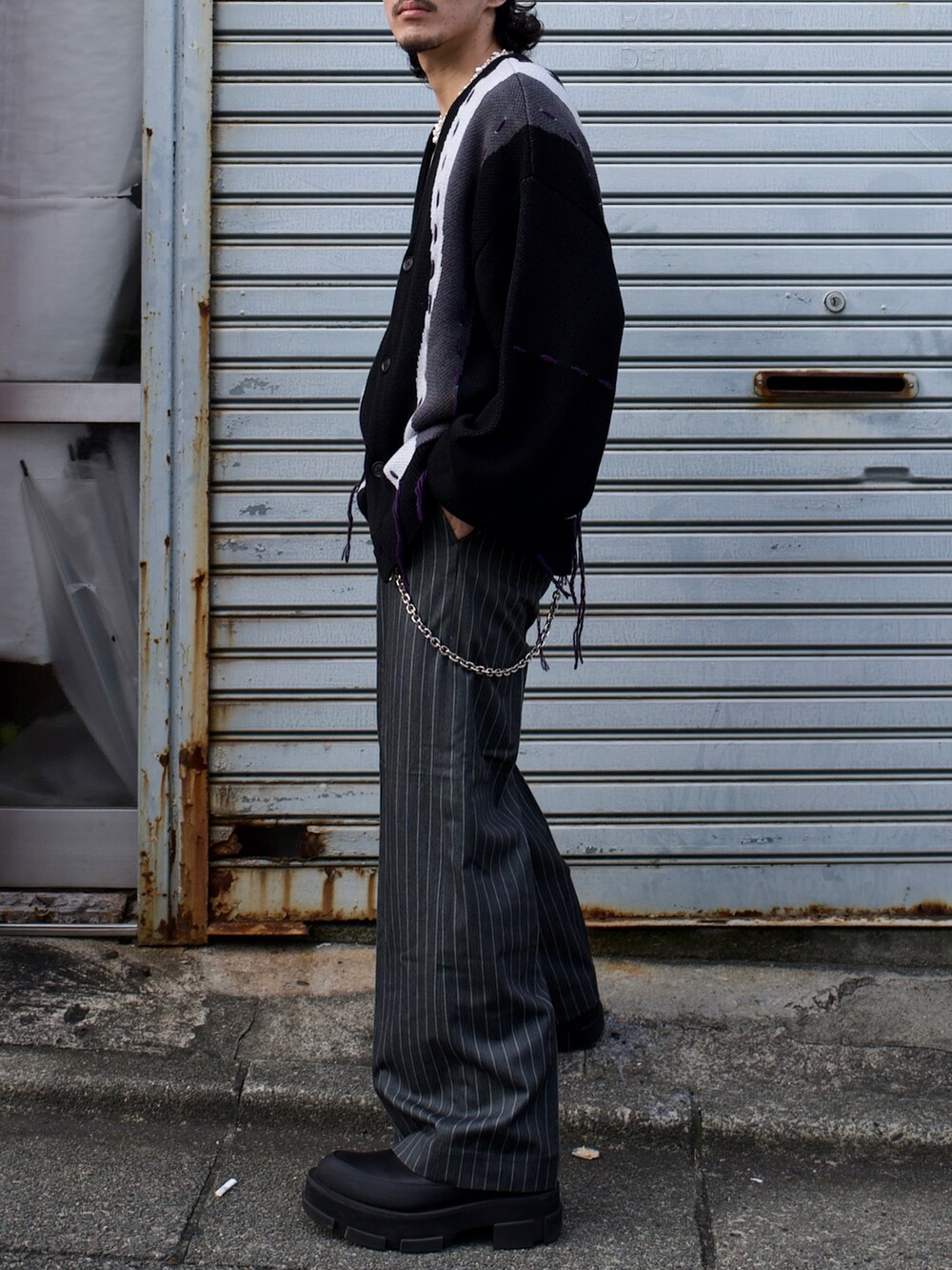 ブラック系のカーディガン/ボレロ、グレー系のパンツを着用したメンズの秋コーディネートの2枚目の写真