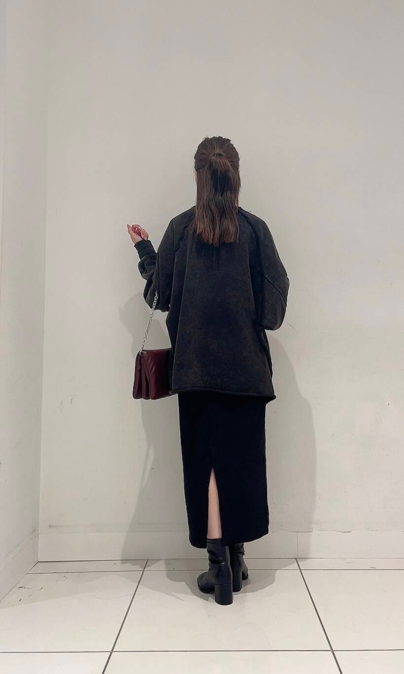 ブラック系のスカート、ブラック系のブーツ、レッド系のショルダーバッグを着用したレディースの秋コーディネートの5枚目の写真