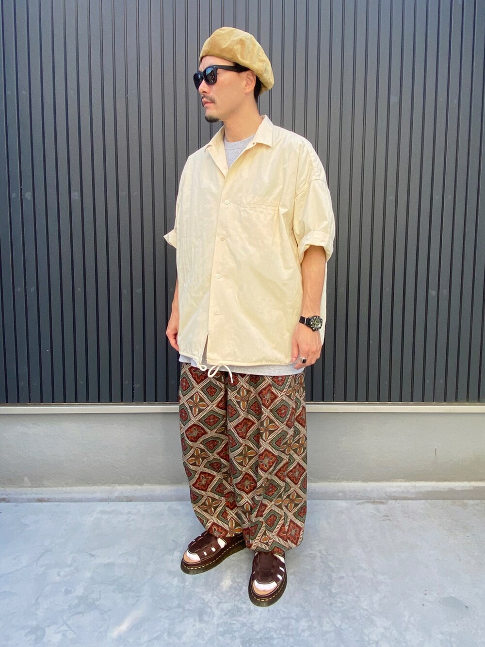 ベージュ系のトップス、グレー系のTシャツ/カットソー、ブラウン系のシューズを着用したメンズの夏コーディネートの3枚目の写真