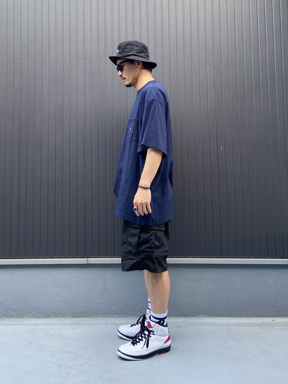 ブルー系のTシャツ/カットソー、ブラック系のパンツ、ホワイト系のスニーカーを着用したメンズの夏コーディネートの2枚目の写真