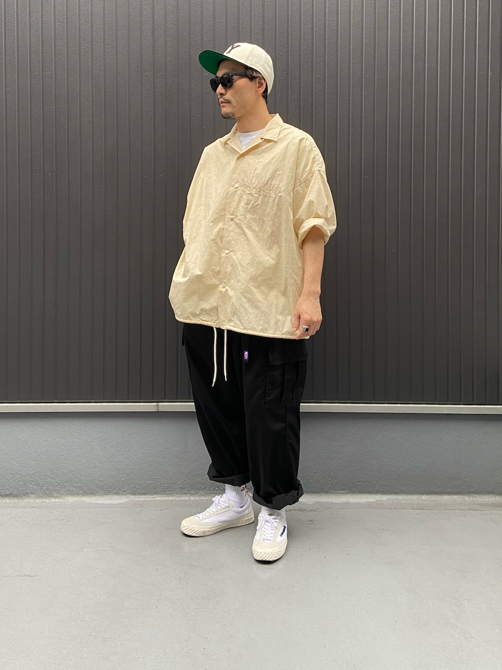 ベージュ系のトップス、ホワイト系のTシャツ/カットソー、ブラック系のカーゴパンツを着用したメンズの夏コーディネートの3枚目の写真