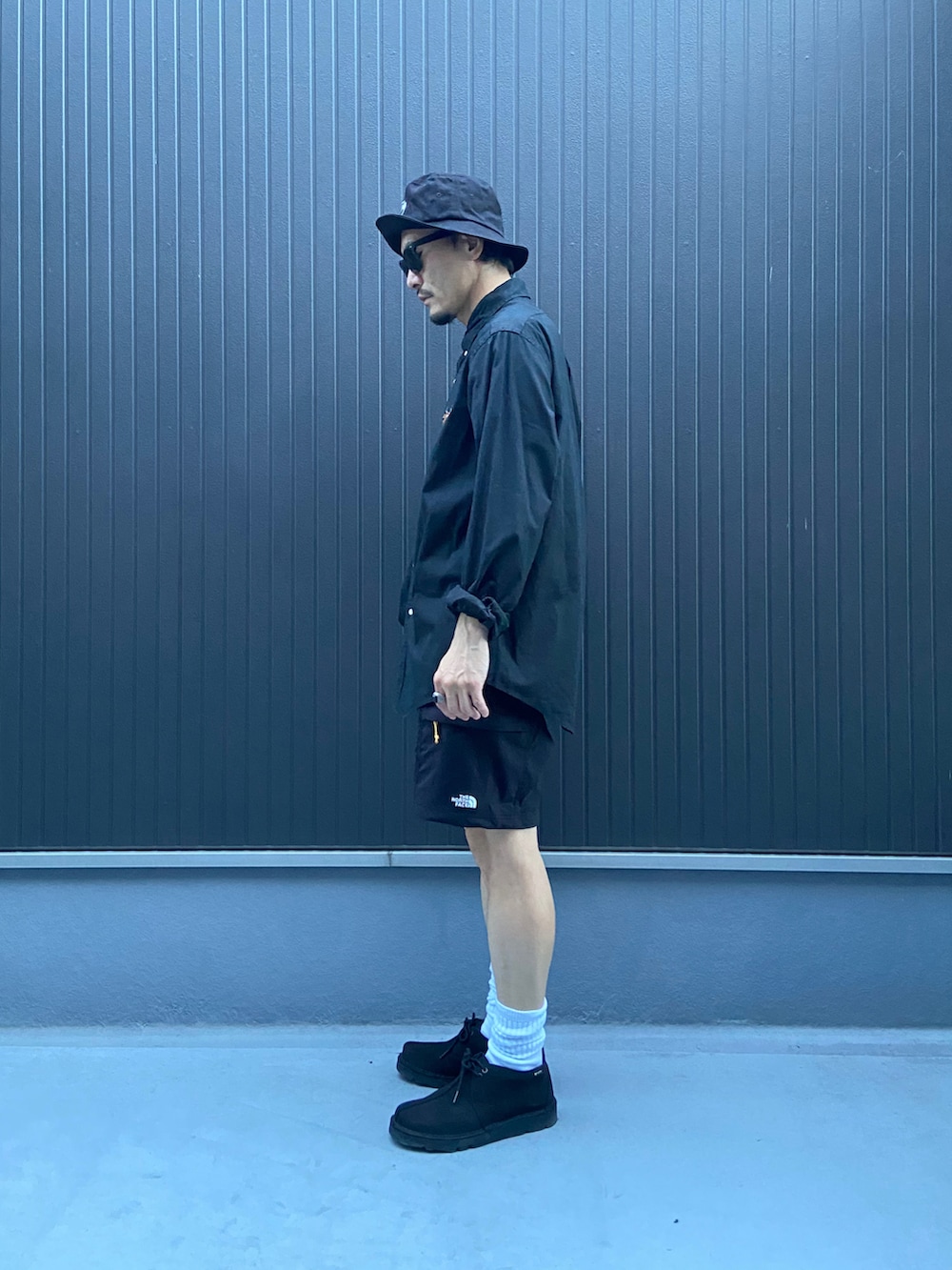 ブラック系のシャツ/ブラウス、ブラック系のパンツ、ブルー系のモカシン/デッキシューズを着用したメンズの秋コーディネートの2枚目の写真