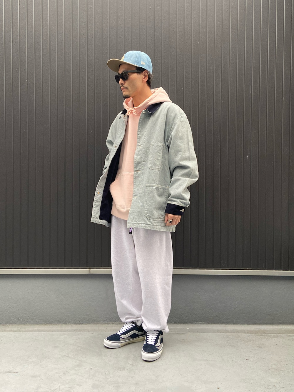 ブルー系のカバーオール、ピンク系のパーカー、グレー系のスウェットパンツを着用したメンズの冬コーディネートの3枚目の写真