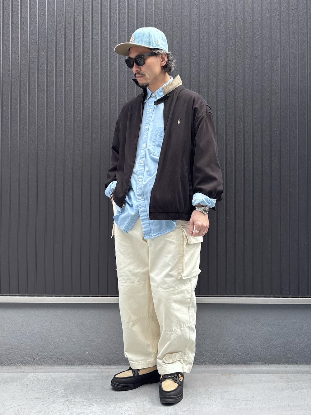 ブルー系のシャツ/ブラウス、ブラック系のジャケット/アウター、ホワイト系のカーゴパンツを着用したメンズの春コーディネートの3枚目の写真