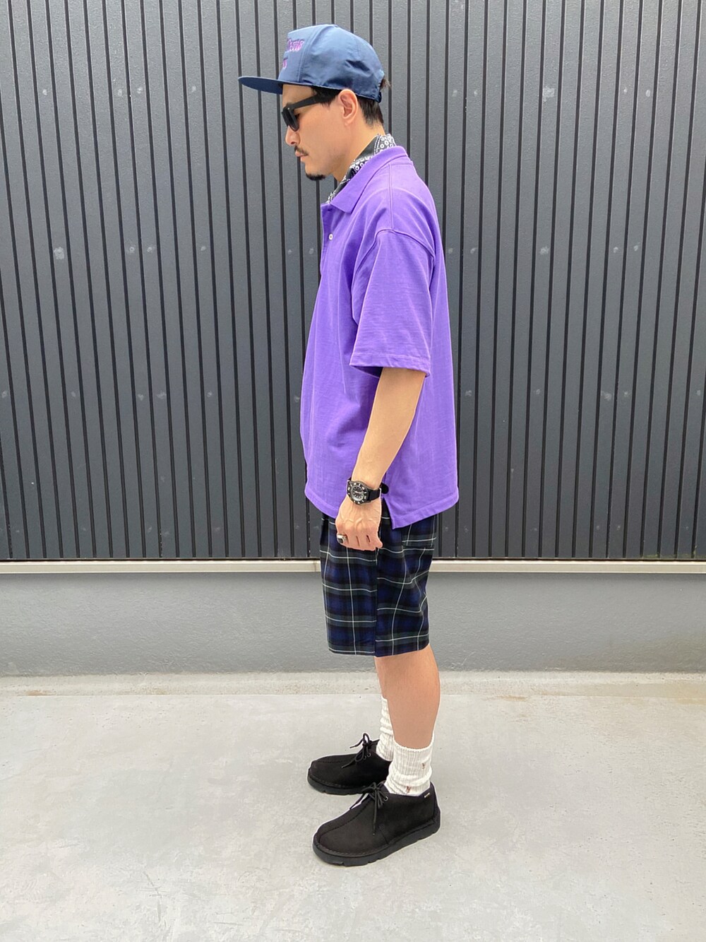 パープル系のポロシャツ、その他のパンツ、ブルー系のモカシン/デッキシューズを着用したメンズの夏コーディネートの2枚目の写真