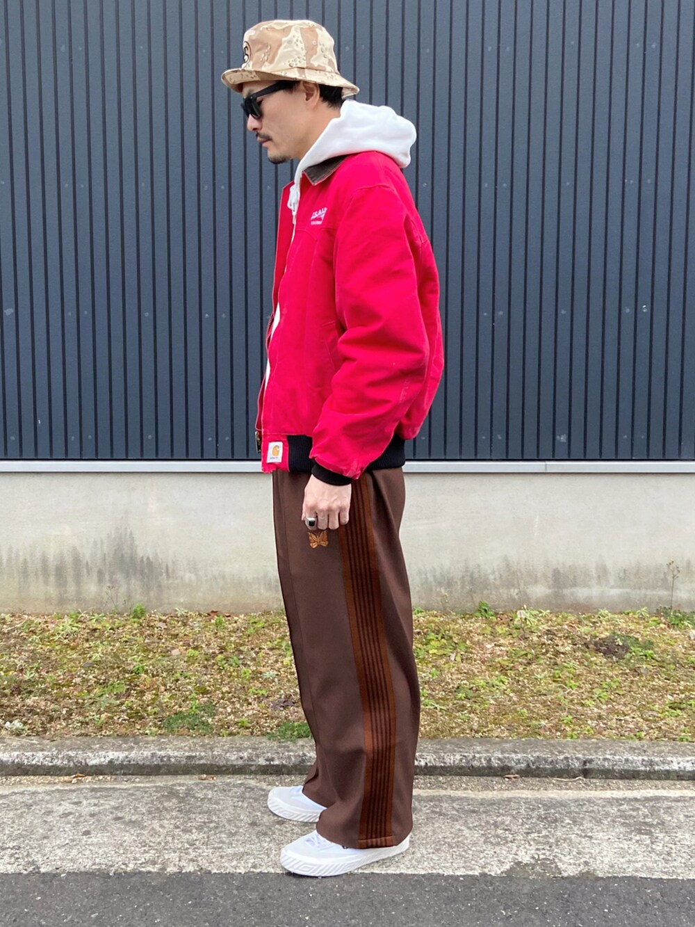 レッド系のジャケット/アウター、ホワイト系のパーカー、ブラウン系のパンツを着用したメンズの冬コーディネートの2枚目の写真