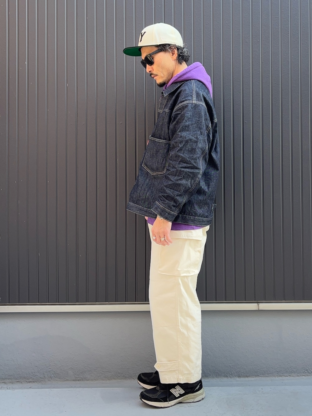 パープル系のパーカー、ブラック系のスニーカー、ブルー系のデニムジャケットを着用したメンズの冬コーディネートの2枚目の写真