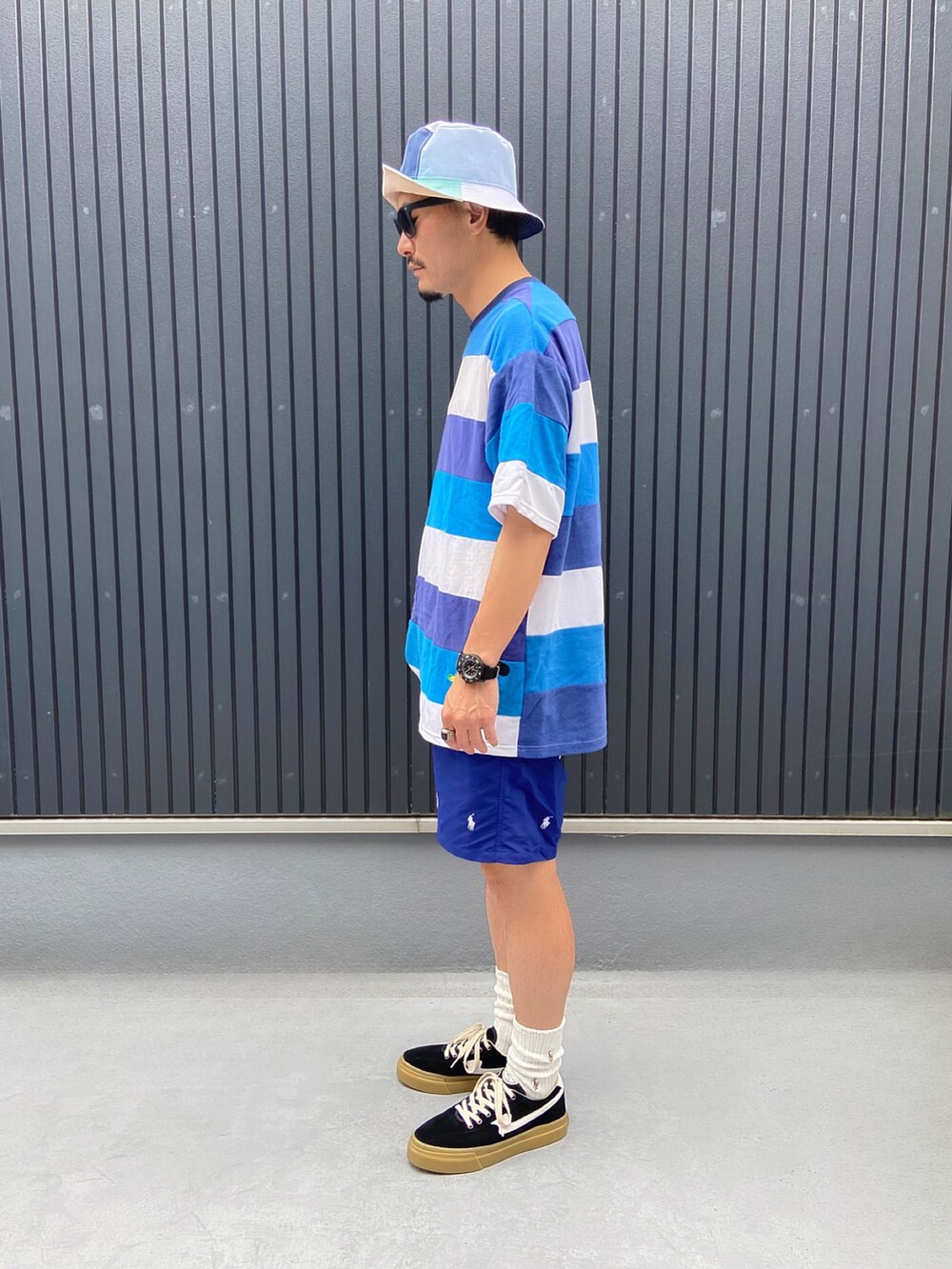 その他のTシャツ/カットソー、ブラック系のスニーカー、その他のハットを着用したメンズの夏コーディネートの2枚目の写真