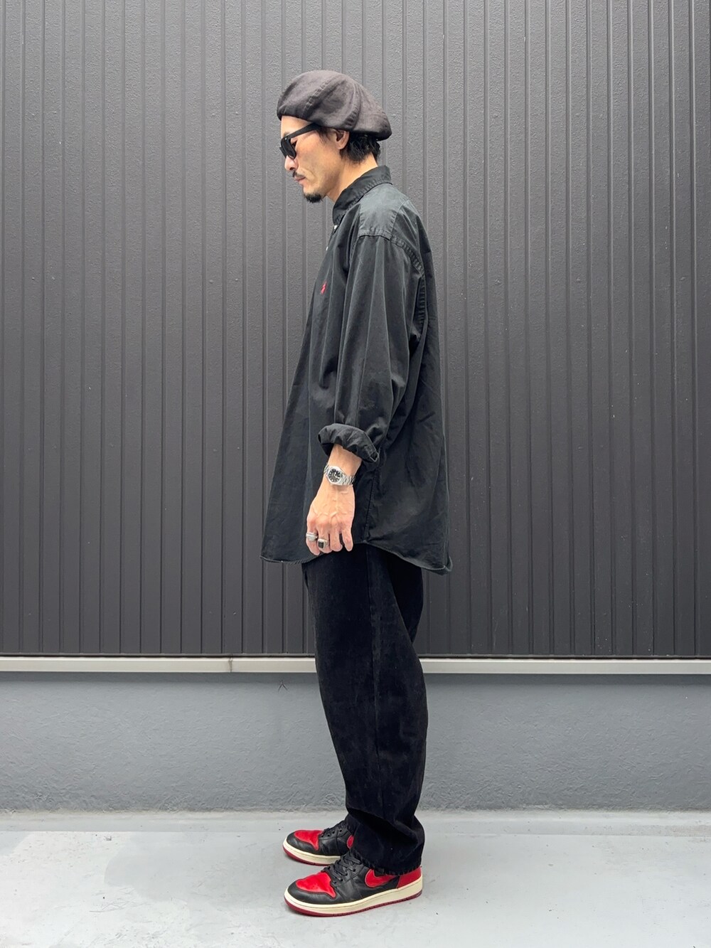 ブラック系のシャツ/ブラウス、ブラック系のデニムパンツ、レッド系のスニーカーを着用したメンズの秋コーディネートの2枚目の写真