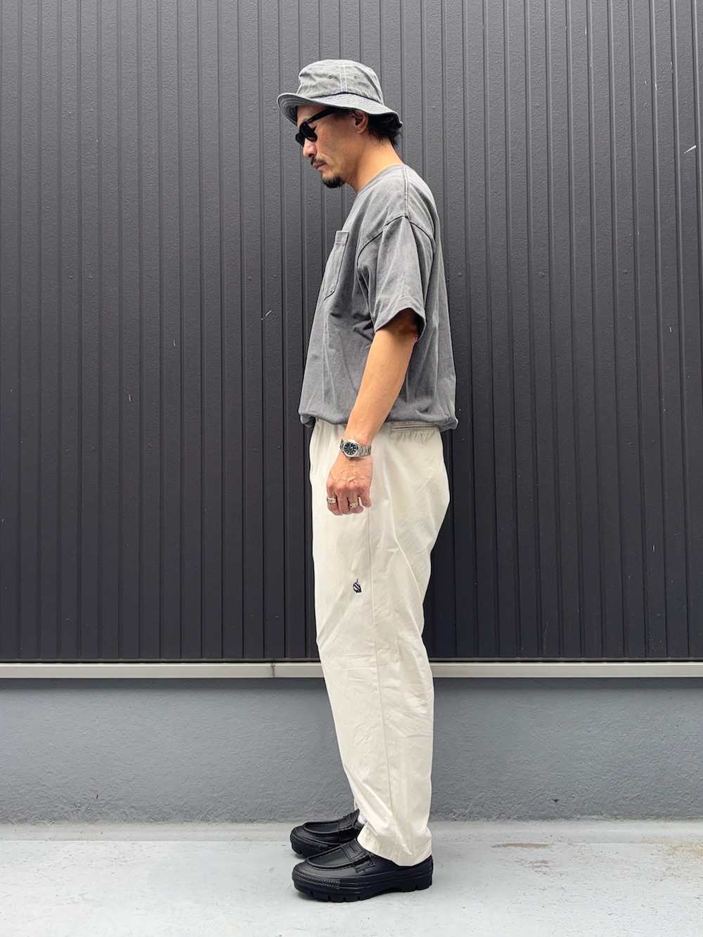 ホワイト系のその他パンツ、ブラック系のTシャツ/カットソー、ブラック系のローファーを着用したメンズの秋コーディネートの2枚目の写真