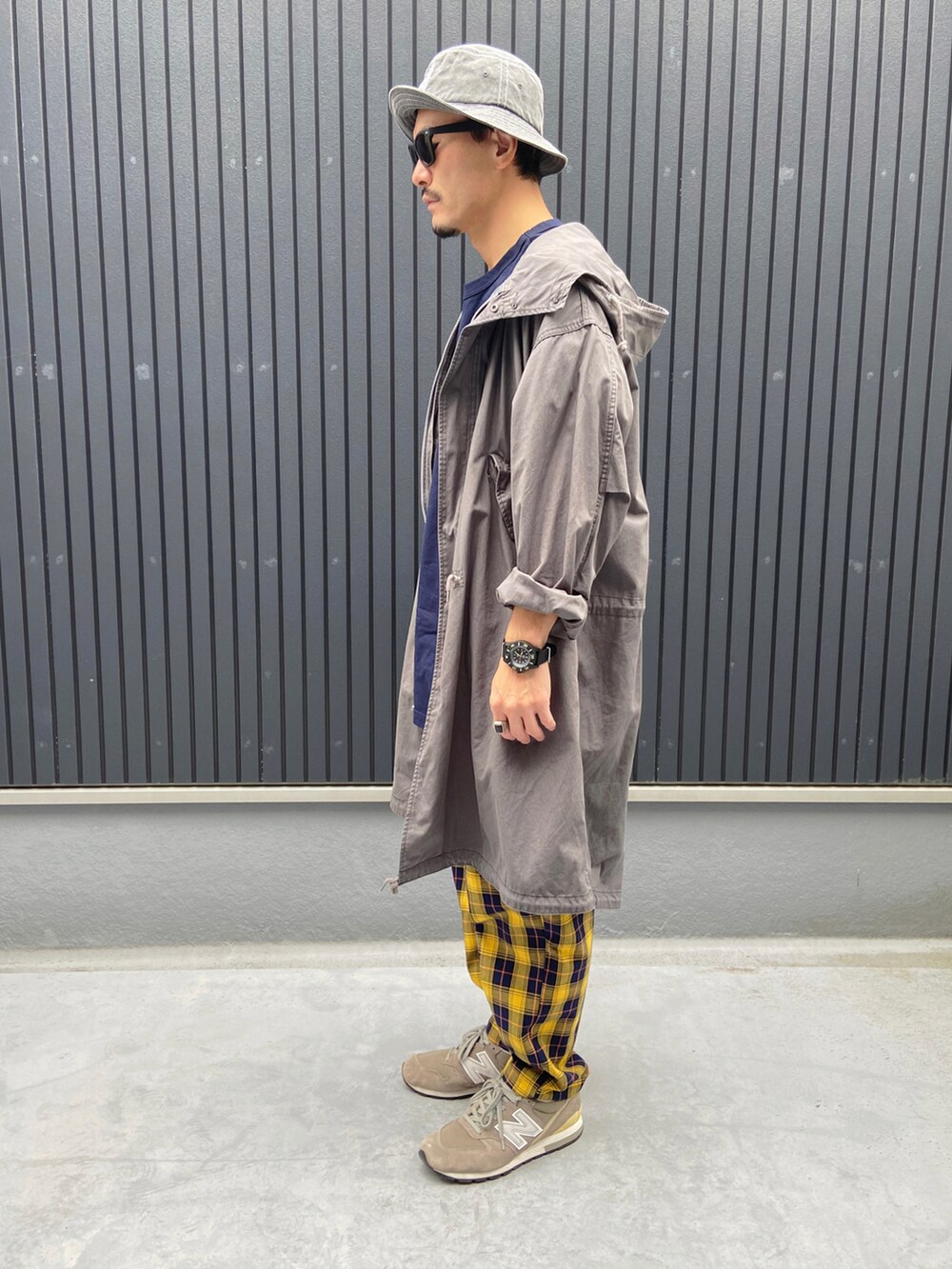 グレー系のモッズコート、ブルー系のTシャツ/カットソー、イエロー系のその他パンツを着用したメンズの秋コーディネートの2枚目の写真