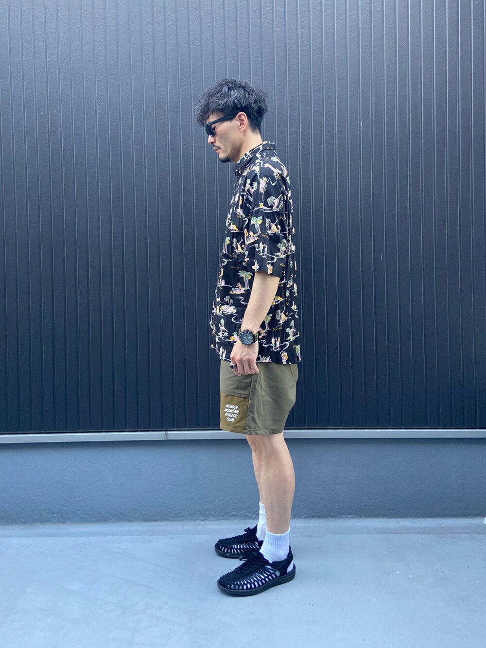 ブラック系のシャツ/ブラウス、ベージュ系のパンツ、ブラック系のサンダルを着用したメンズの夏コーディネートの2枚目の写真