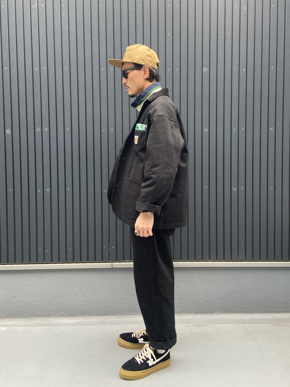 ブラック系のジャケット/アウター、グリーン系のナイロンジャケット、ブラック系のパンツを着用したメンズの春コーディネートの2枚目の写真