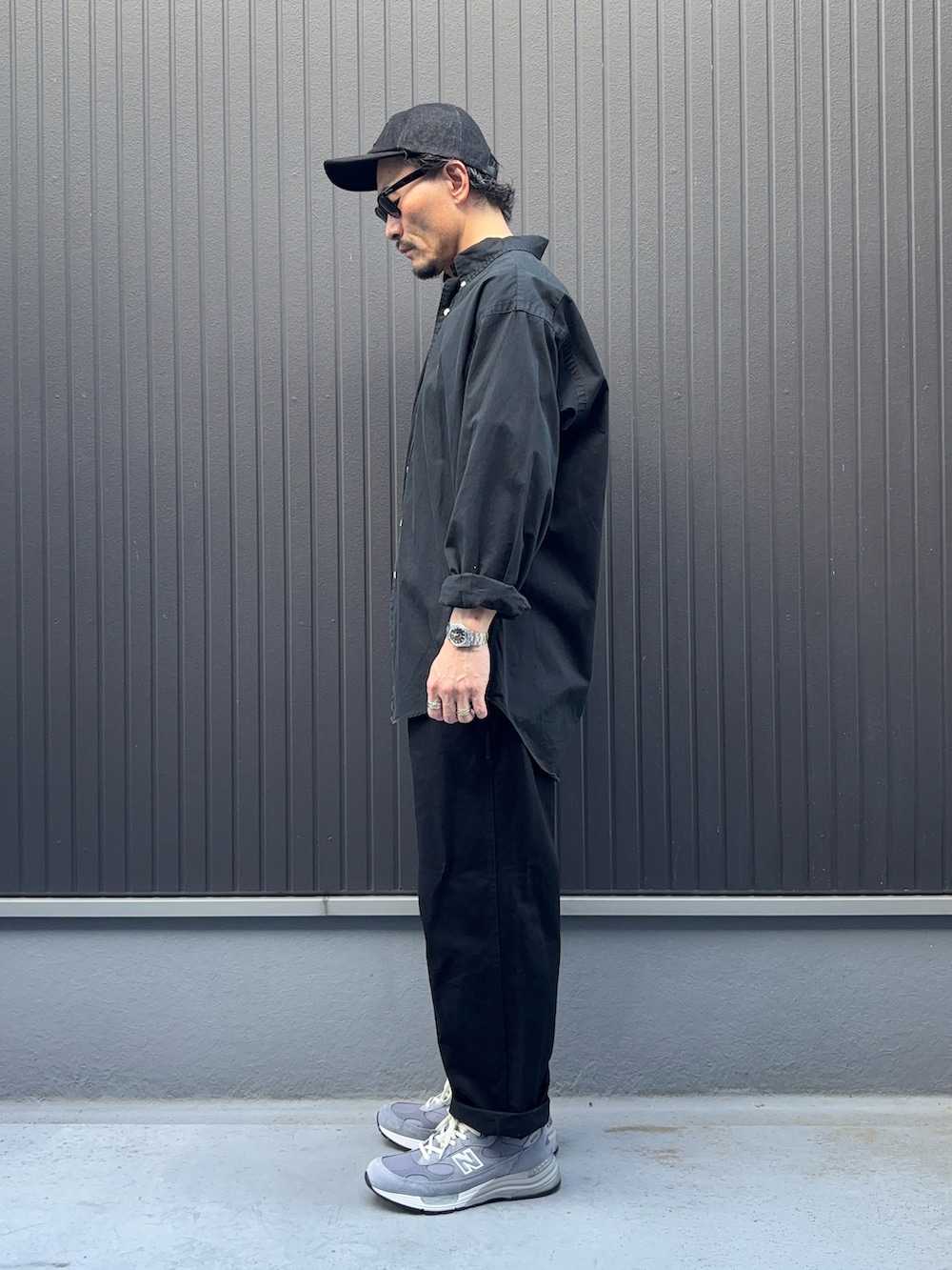 グリーン系のシャツ/ブラウス、ブラック系のパンツ、グレー系のスニーカーを着用したメンズの夏コーディネートの2枚目の写真