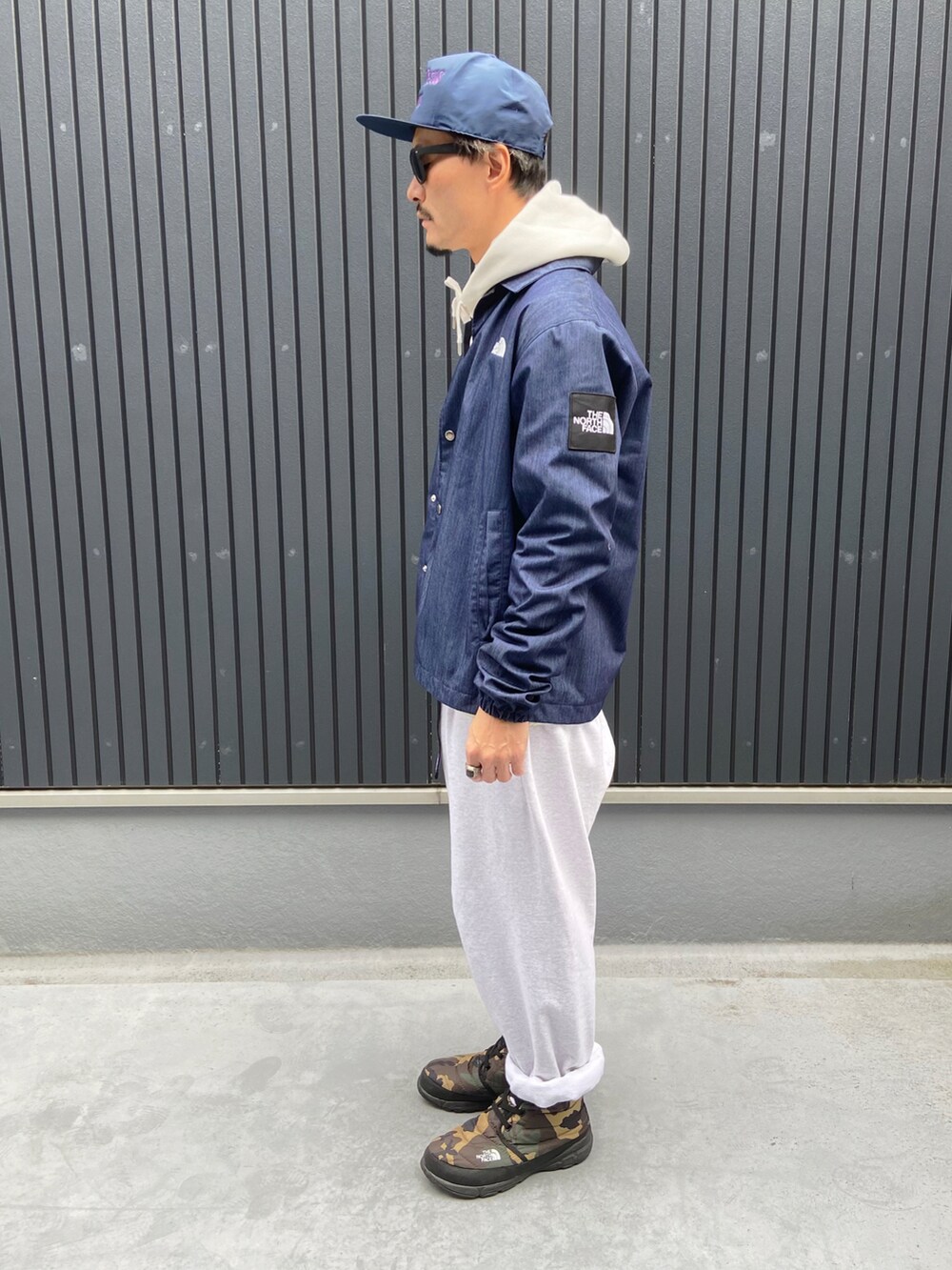 ブルー系のブルゾン、ホワイト系のパーカー、ホワイト系のTシャツ/カットソーを着用したメンズの冬コーディネートの2枚目の写真